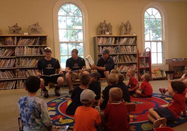 Harwich Mariners at Brooks Free Library with children sitting on the floor