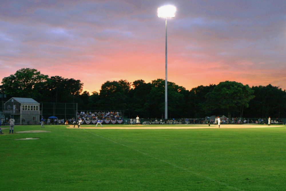 Harwich Mariners baseball game at sunset under lights