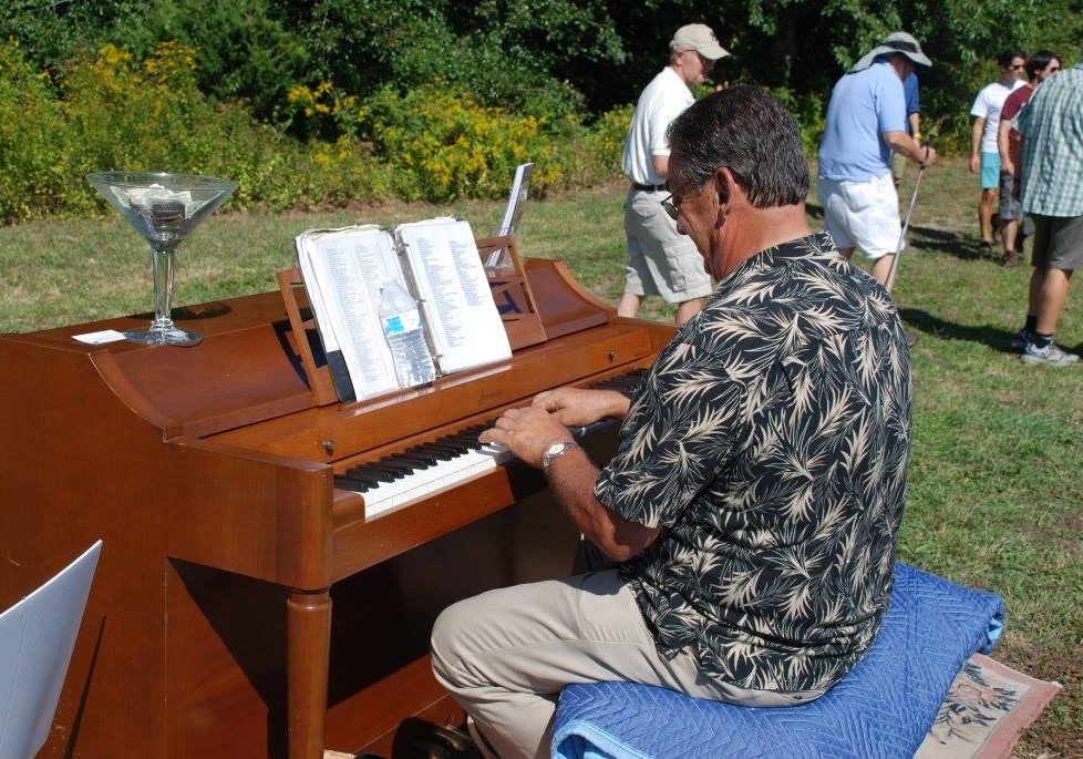 Tom Telesmanick playing piano outdoors