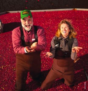 Smiling cranberry growers standing in cranberry bog