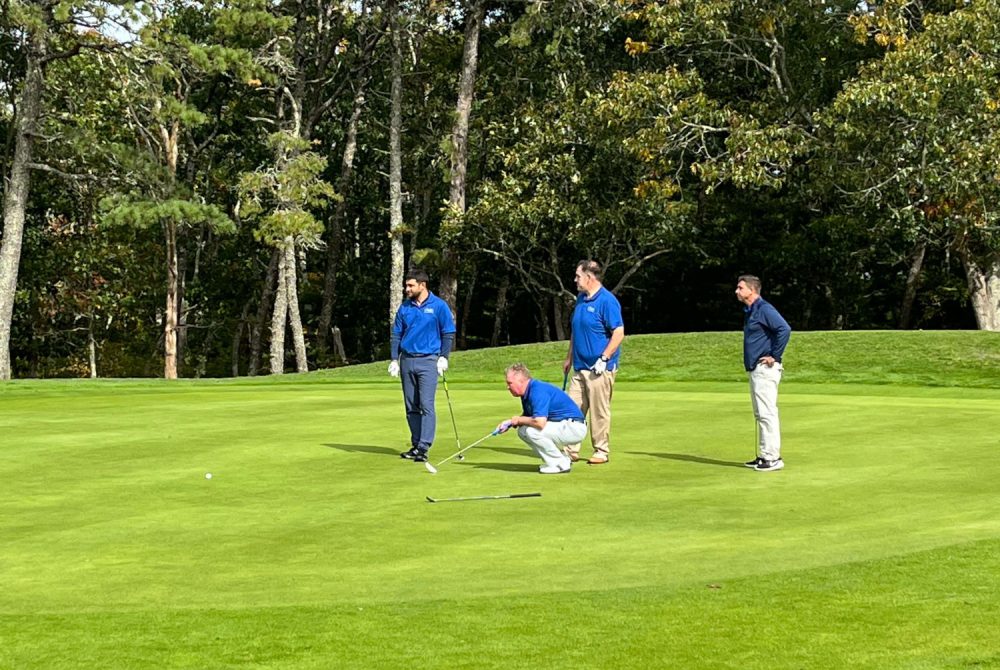 Four golfers on Harwich golf course green